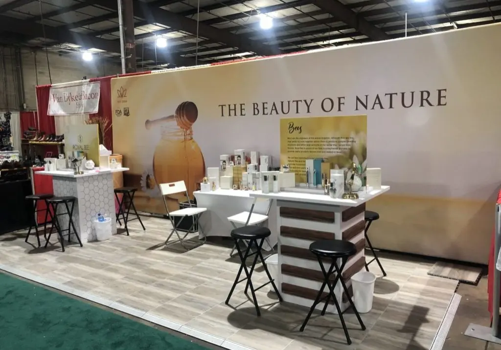 Botanical exhibit backdrop with product counters and demonstration seating